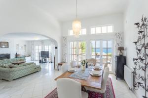 uma sala de jantar e sala de estar com mesa e cadeiras em Top Cliff Villa with ocean view and pool at stunning cliffs no Burgau