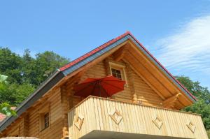a red umbrella on the side of a log cabin at Schwalli's Ferienhaus Am Wipperberg in Korbach