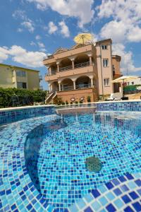 a large swimming pool in front of a building at Apartments Tony in Biograd na Moru