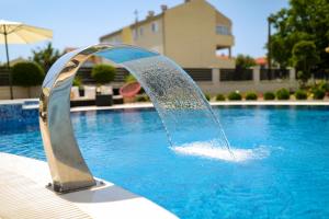 une fontaine dans la piscine dans l'établissement Apartments Tony, à Biograd na Moru