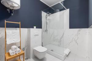 a white bathroom with a shower and a toilet at Apartments Carpathia in Rijeka +42 photos