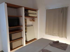 um quarto com uma cama, um frigorífico e uma janela em SAND & WAVES HOUSE em Andiparos