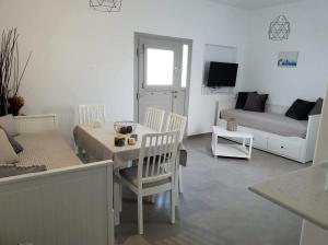 uma sala de estar com uma mesa e um sofá em SAND & WAVES HOUSE em Andiparos