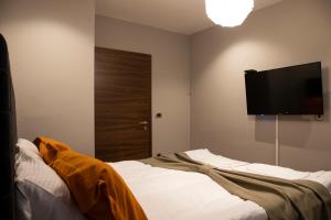 a bedroom with a bed and a flat screen tv at Boulevard Center 92 in Pristina