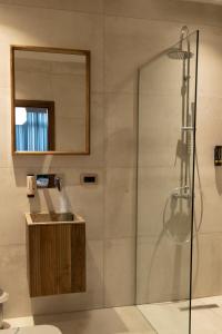 bagno con doccia, lavandino e specchio di Boulevard Center 92 a Pristina