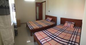 two beds in a small room with at Gia Anh Guesthouse in Hue