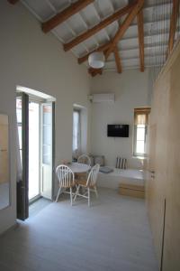 a living room with a table and chairs and a bed at L Anima in Skiathos