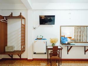 a room with a table and a mirror and a refrigerator at Rendezvous Oldtown Chiangmai in Chiang Mai