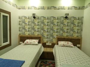 プリーにあるMadhusmrutiの写真付きの壁のある客室で、ベッド2台が備わります。