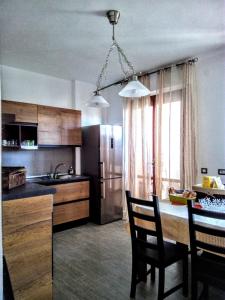 a kitchen with a table with chairs and a refrigerator at B&B Libellula in Iglesias