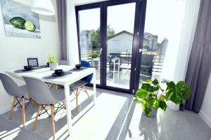 ウェバにあるAWO Apartamentyの窓付きの客室で、白いテーブルと椅子が備わります。