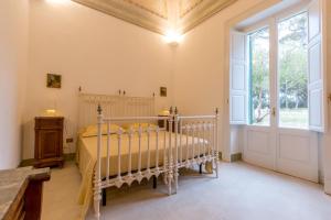 ein Schlafzimmer mit einem Bett und einem großen Fenster in der Unterkunft Villa Giulio B&B DImora Storica in Santa Caterina di Nardò