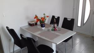 a white table with black chairs and flowers on it at Apartman Mali Tare in Korčula +10 photos
