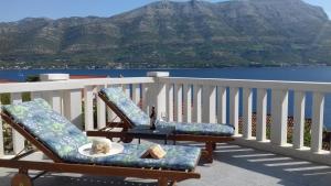 een tafel en stoelen op een balkon met uitzicht op een berg bij Apartman Mali Tare in Korčula