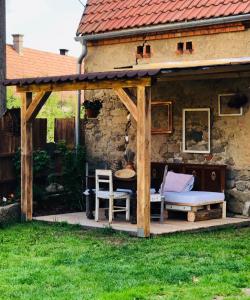 einen hölzernen Pavillon mit einer Bank und einem Tisch in der Unterkunft Ubytování v malebné vesničce in Mirotice