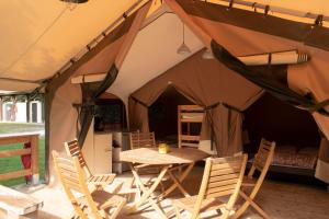 a tent with a table and chairs in it at Camping L'îlot du Chail in Sansais