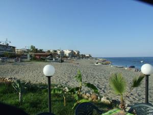 a beach with some chairs and the ocean at Villa Spaia in Brancaleone Marina