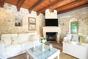 a living room with a white couch and a fireplace at Villa Pasiphae in Kamilari