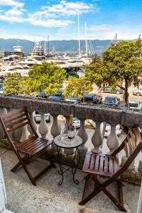 twee stoelen en een tafel op een balkon met een haven bij Apartment Mia in Rijeka