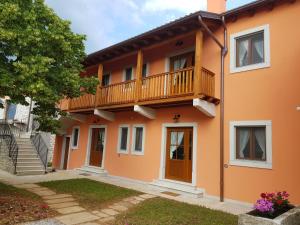 得利雅斯特的住宿－Agriturismo Kralj，橙色的房子设有阳台和楼梯