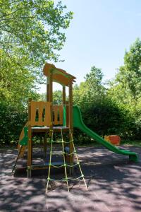 a playground with a slide and two chairs at Camping L'îlot du Chail in Sansais