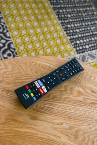 a remote control sitting on top of a wooden table at Cosy House in the heart of Beeston with FREE Parking and WiFi in Nottingham