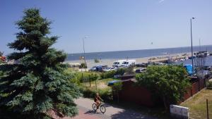 a person riding a bike next to a beach at ORKAN 2 in Kuźnica
