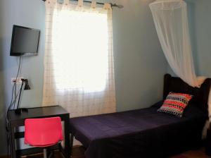 a bedroom with a bed and a desk and a window at Casa Rural Los Membrillos in Teba