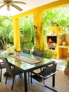 a patio with a table and chairs and a fireplace at Casa Rural Los Membrillos in Teba
