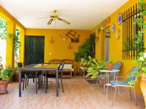 a dining room with yellow walls and a table and chairs at Casa Rural Los Membrillos in Teba