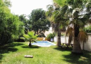 a yard with a swimming pool and palm trees at Casa Rural Los Membrillos in Teba