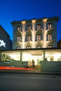 un bâtiment avec une personne qui marche devant lui dans l'établissement Hotel Sirio, à Lido di Camaiore