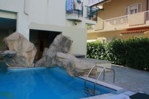 a swimming pool with a large rock next to a building at Residence Le Vele in Cattolica