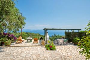 a patio with chairs and a table and a pergola at Villa Eleonas in Ieromónachos