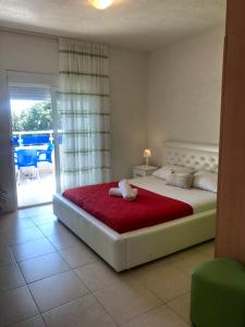 una camera da letto con un grande letto con una coperta rossa di Apartmani Dini a Ulcinj