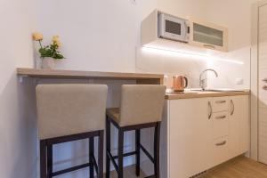 a kitchen with two bar stools and a microwave at Villa Stonehouse in Milna