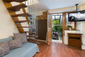 ein Wohnzimmer mit einer Treppe und einem TV in der Unterkunft Old Town Garden Apartments in Dubrovnik