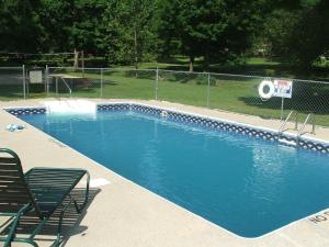 a large blue swimming pool in a park at Wilstem Cabins in French Lick