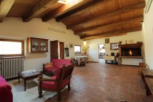 a living room with a red couch and a fireplace at Agriturismo Il Giardino in Sansepolcro