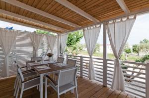 een eetkamer met een tafel en stoelen op een terras bij Camp San Antonio in Biograd na Moru