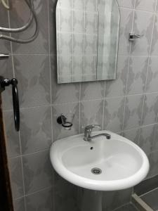 y baño con lavabo blanco y espejo. en Apartaments Queen, en Ulcinj
