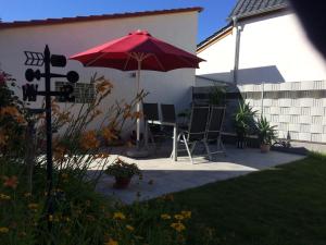 d'une terrasse avec une table et un parasol rouge. dans l'établissement Schöne zwei Zimmer Wohnung, à Walldorf