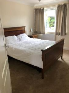 a bedroom with a large bed with white sheets and a window at Henry,s Place in Great Torrington