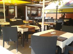 un restaurante con mesas, sillas y sombrilla en Rooms Luna Sol, en Krnica