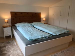 a bed with blue sheets and pillows in a bedroom at Apartment 5 in Wyk auf Föhr