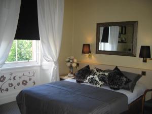 a bedroom with a bed with pillows and a mirror at Thistle Hotel in Edinburgh