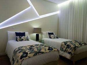 two beds in a room with a sloped ceiling at INNature in Ponta Delgada
