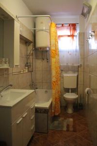 uma casa de banho com um lavatório, um WC e uma banheira em Aura em Jadranovo