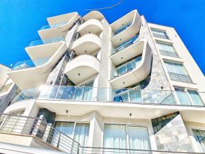 a white building with balconies on the side of it at Hotel Pierina in Budva