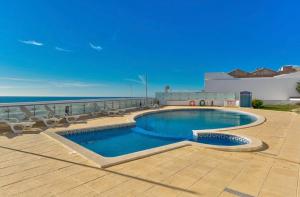 a swimming pool on top of a building next to the ocean at Carvoeiro Bay Apartment in Carvoeiro